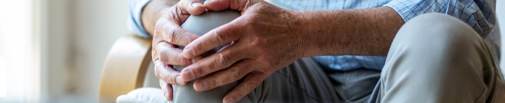Mężczyzna trzymający się za kolano, cierpiący na osteoporozę